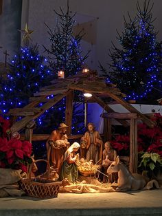 a nativity scene with blue lights and christmas trees