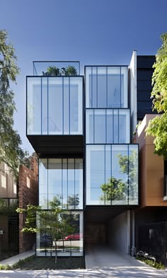 an unusual house with glass walls and lots of windows on the side of the building