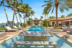 an outdoor swimming pool surrounded by palm trees