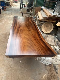 a large wooden table sitting on top of a pile of wood planks in a warehouse