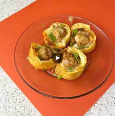 some food is on a glass plate on a red place mat next to an orange tablecloth