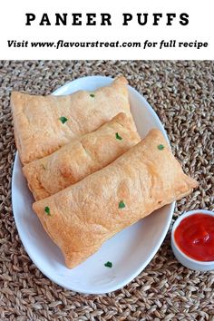 two pieces of bread on a plate with ketchup next to it and the words, paneer puffs