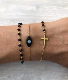 Protect yourself from negative energy and elevate your style with our Evil Eye Bracelet Set. This set includes three unique bracelets, all made from high-quality sterling silver 925 and plated in gold. The first bracelet features a beautiful evil eye charm, while the second showcases a stunning black rosary chain. The third bracelet features a unique handmade chain made half from usual chain and half from rosary beads. Perfect for any occasion, these bracelets are a must-have for any fashion-for Black Evil Eye, Black Rosary, Layered Bracelet, Greek Evil Eye, Handmade Chain, Rosary Bracelet, Rosary Chain, Rosary Beads, Unique Bracelets