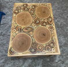 a table made out of wood with circles and holes in the center on carpeted area