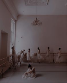 a group of women in white dresses are dancing