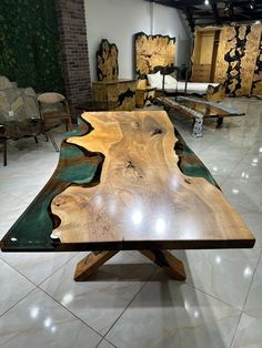 a table made out of wood and glass in a room filled with chairs, tables and couches