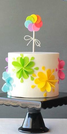 a white cake with multi colored flowers on it