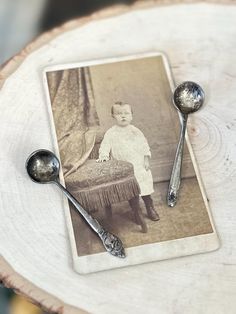 an old photo with two spoons on top of it next to a piece of wood