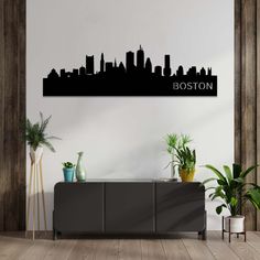 the houston skyline in black and white on a wall above a buffet with potted plants