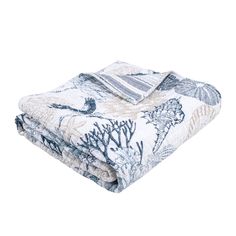 the blue and white bedding is folded up on top of each other, with an ocean theme