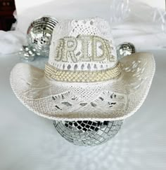 a white cowboy hat with the word rid on it sitting on top of a bed