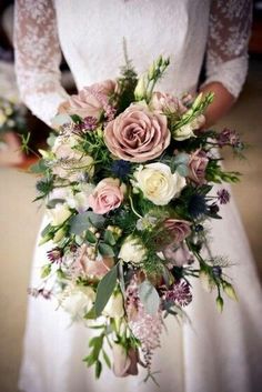 a bride holding a bouquet of flowers on her wedding day in front of the camera