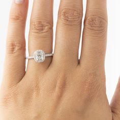 a woman's hand with a white diamond ring on top of her left hand