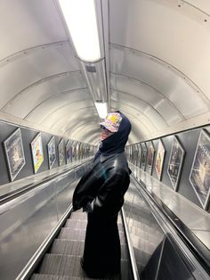 a man riding an escalator with pictures on the wall