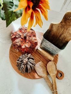 a wooden cutting board topped with lots of different types of items next to a sunflower