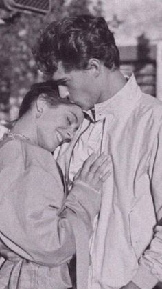 black and white photograph of a couple embracing each other in front of a street light