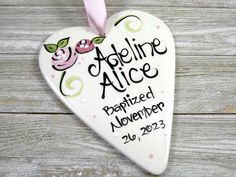 a ceramic heart shaped ornament with the name and date on it