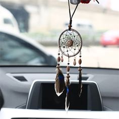 a car dashboard with a dream catcher hanging from it's center console