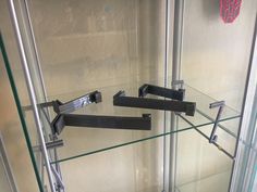 two glass shelves with metal brackets on them