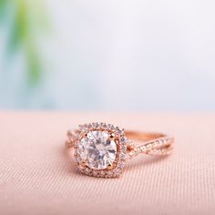 an engagement ring on top of a pink cloth