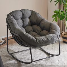 a chair that is sitting in the middle of a room with a potted plant next to it