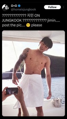 a man with no shirt standing on top of a boat next to another person holding a camera