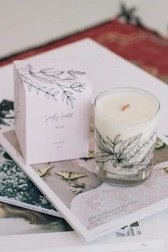 a candle sitting on top of a table next to a box and some pictures in front of it