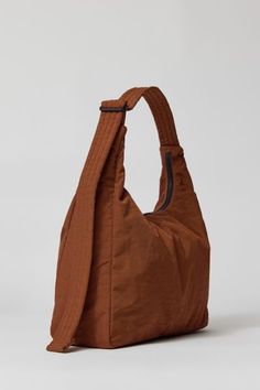 Our new fave BAGGU design made from recycled materials. Structured shoulder bag silhouette with a zip top and stitched adjustable shoulder strap. Content + Care. 100% Heavyweight nylon with 59% recycled content Machine wash Imported Size. Dimensions: 14" l x 4" d x 10.5" h Strap drop: 27.5" l Brown Nylon Shoulder Bag For Daily Use, Nylon Hobo Shoulder Bag With Zipper Pocket, Everyday Nylon Hobo Shoulder Bag, Brown Nylon Shoulder Bag For On-the-go, Everyday Nylon Shoulder Hobo Bag, Everyday Nylon Hobo Bag With Removable Pouch, Brown Nylon Shoulder Bag For Everyday Use, Brown Nylon Shoulder Bag With Zipper Pocket, Functional Nylon Hobo Bag For Everyday Use