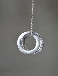 "Stylish and timeless sterling silver interlocking circle pendant. One ring has been hammered for a beautiful texture, and the other has been given a satin finish. The pendant hangs on a sterling silver belcher chain. Circles are approximately 2.5 cm (0.9\") in diameter The necklace will come in a beautiful gift box. * CHECK OUT MORE JEWELLERY * www.etsy.com/shop/kailajewellery" Hammered White Gold Jewelry For Gift, Sterling Silver Oval Pendant, Sterling Silver Oval Pendant With Clasp, Sterling Silver Jewelry With Oval Pendant, Sterling Silver Hammered Jewelry Gift, Hammered Sterling Silver Jewelry Gift, Hammered White Gold Jewelry Gift, Hammered Sterling Silver Jewelry For Gifts, Hammered Sterling Silver Necklaces In Silver