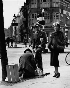 an old black and white photo of people on the street