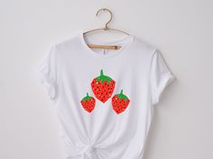 Strawberry Shirt, perfect for a fun summer day! PRODUCT DETAIL Unisex Jersey Short Sleeve Tee ▪ 100% Airlume combed and ring-spun cotton (fiber content may vary for different colors) ▪ Light fabric ▪ Retail fit ▪ Tear away label ▪ Runs true to size (for an oversized fit, size up to one) CARE INSTRUCTIONS ▪ Machine wash: warm (max 40C or 105F) ▪ Non-chlorine: bleach as needed  ▪ Tumble dry: low heat ▪ Iron, steam or dry: medium heat ▪ Do not dry clean. PROCESSING TIME ▪ 2-7 DAYS IMPORTANT REMINDERS ▪ Please check the size guide carefully before purchase.  ▪ Please make sure your default address on Etsy is correct before purchase.  PLEASE NOTE ▪ Print size may vary depending on the size of the shirt. ▪ Colors may vary slightly in print from on screen depending on the device you're using. RET Strawberry Botanical, Botanical Cottagecore, Strawberry T Shirt, Tshirt Aesthetic, Fruit Shirt, Strawberry Shirt, T Shirt Aesthetic, Cottagecore Shirt, Aesthetic Garden