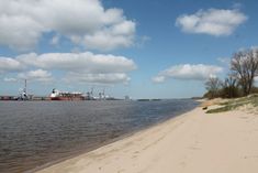 there is a large ship in the distance on the water and sand by the beach