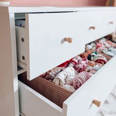 an open drawer with baby clothes in it