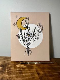 a painting on a wooden table with flowers and the moon in the sky above it