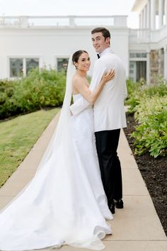 a bride and groom standing in front of a building