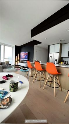 a living room filled with lots of furniture and a flat screen tv mounted to the wall