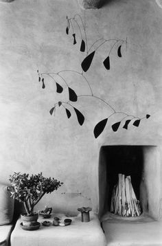 an old photo of a fireplace with plants on the mantle