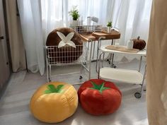 three inflatable tomatoes sit on the floor next to each other near a window