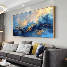 a living room filled with furniture and a large painting on the wall above it's couch