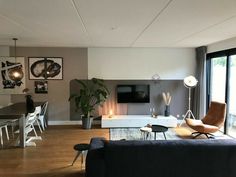 a living room filled with furniture and a flat screen tv mounted on the wall above a fireplace