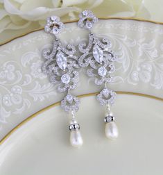 Rose gold cubic zirconia Bridal earrings in a modern vintage style chandelier style. Choose crystal drop or pearl drop from the drop down menu. Earrings are a perfect statement piece for any bride or other special occasion. Earrings measure 3 inches long and are 1 inch at their widest. Available in rose gold or rhodium finish. Back to my shop: https://www.etsy.com/shop/TheExquisiteBride?ref=condensed_trust_header_title_items Classic Cubic Zirconia Chandelier Earrings For Wedding, Exquisite Wedding Chandelier Earrings With Cubic Zirconia, Elegant Cubic Zirconia Chandelier Earrings For Wedding, Exquisite Cubic Zirconia Chandelier Earrings For Wedding, Intricate Dangle Bridal Earrings With Cubic Zirconia, Intricate Cubic Zirconia Dangle Bridal Earrings, Cubic Zirconia Bridal Earrings With Intricate Design, Wedding Chandelier Earrings With Intricate Cubic Zirconia Design, Exquisite Silver Chandelier Earrings With Elegant Design