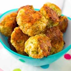 a blue bowl filled with crab cakes on top of a polka dot tablecloth covered table