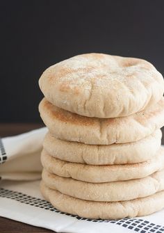 a stack of white bread sitting on top of a table next to a black and white checkered napkin