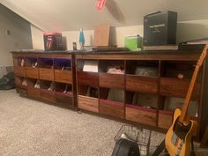 a room with several shelves and guitars on top of the floor, including an electric guitar