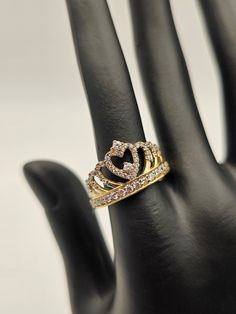 a hand with a ring on it that has a heart in the middle and two smaller hearts