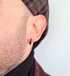 Hoop earring of 14 mm in diameter and 3 mm in caliber, with square shape on the profile, pin closure, with gloss finish. A design with a smaller caliber than those usually seen, which makes them easily combinable with steel models of other sizes as seen in the photographs. The first jewels used by humans of which there is evidence are those found in the Blombos cave, in South Africa, dating back 75,000 years. As for the oldest metal jewels discovered so far, they are 7000 years old, these being Modern Small Hoop Piercings As A Gift, Modern Huggie Piercings As Gift, Modern Huggie Piercings For Gift, Modern Adjustable Huggie Earrings For Pierced Ears, Adjustable Modern Huggie Earrings, Earring For Men, Black Earring, Earrings For Men, Cave In