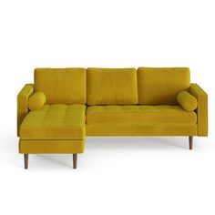 a yellow couch with pillows and a footstool