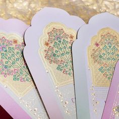 five cards with intricate designs on them sitting next to each other in front of a gold and pink background