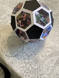 an origami ball with pictures on it sitting on a tablecloth covered table