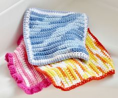 three crocheted dishcloths sitting on top of a white sink next to each other